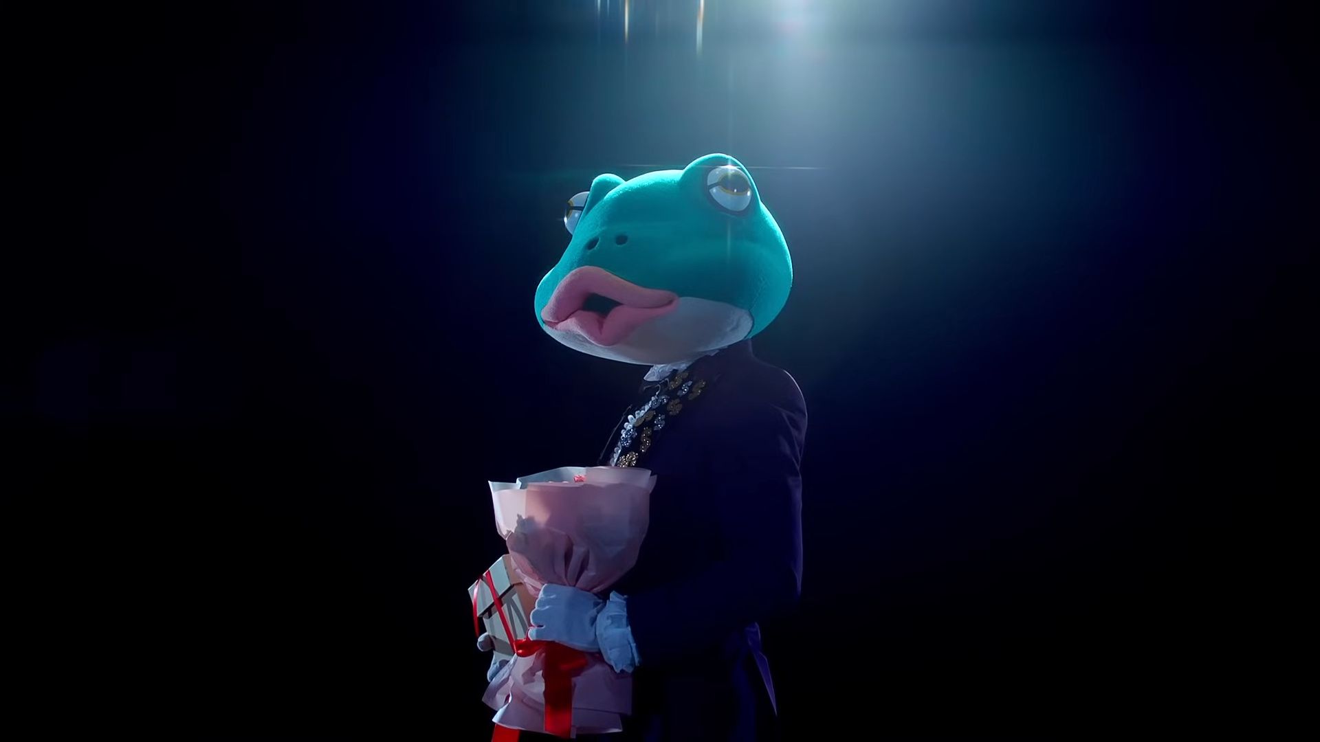 A man wearing a large frog costume head.